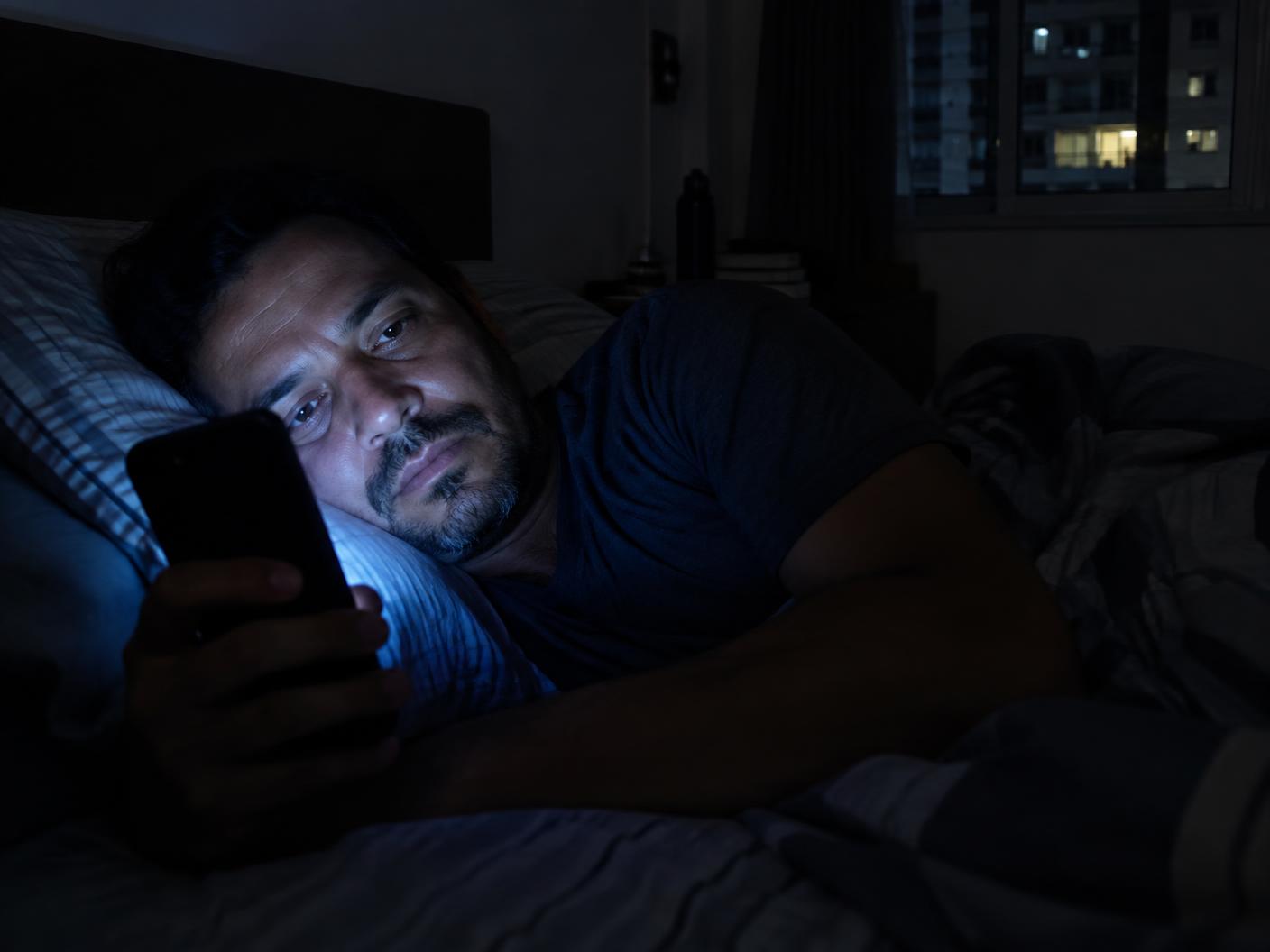Homem com o celular à noite